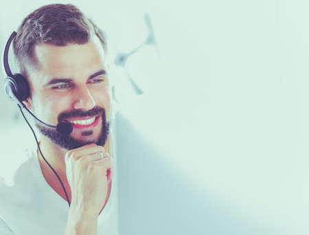 Portrait of a young man with a headset in front of a laptop computerの写真素材