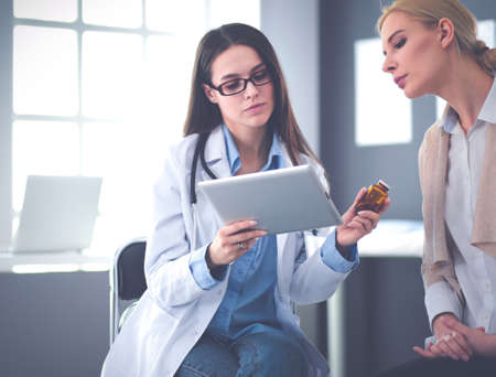 Doctor and patient discussing something while sitting at the table . Medicine and health care conceptの写真素材