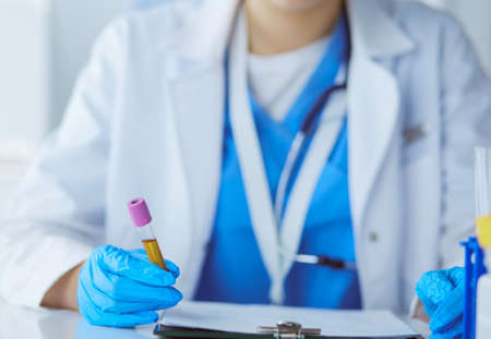 Woman researcher is surrounded by medical vials and flasks, isolated on white backgroundの写真素材