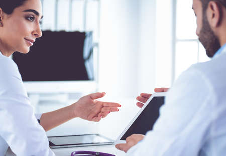 Medical team sitting and discussing at tableの写真素材