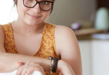Young woman sitting a table in the kitchenの写真素材