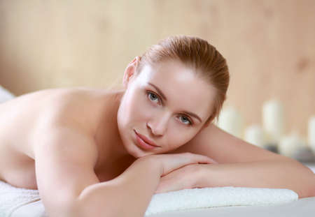 Beautiful young woman getting spa massage, lying on salonの写真素材