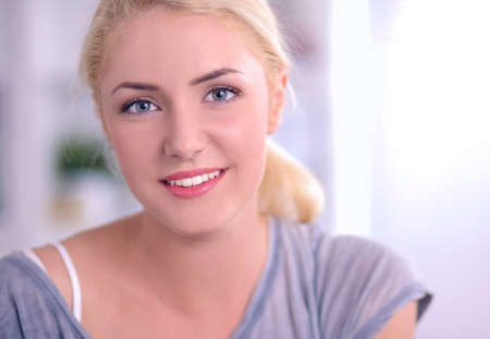 Young beautiful woman sitting on couch at her roomの写真素材