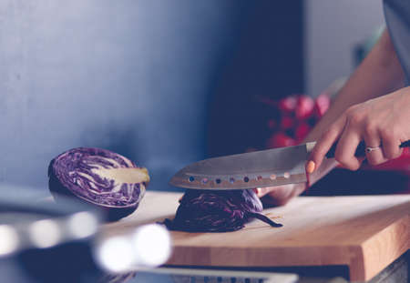 Woman cooking in new kitchen making healthy food with vegetablesの写真素材