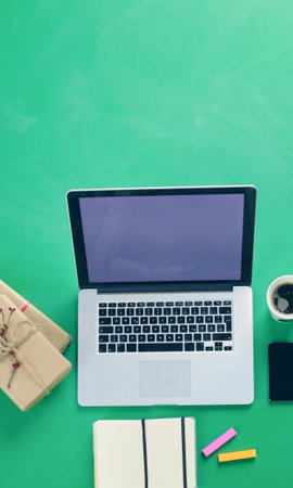 Notebook with gifts and laptop on wooden tableの写真素材