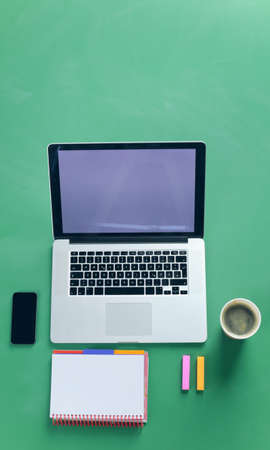 Office desk table with laptop, smart phone, photocameraの写真素材
