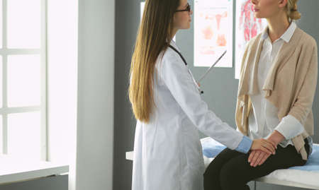 Doctor and patient discussing something while sitting at the table . Medicine and health care conceptの写真素材