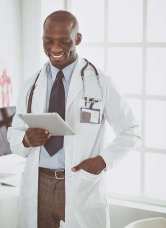 Male black doctor worker with tablet computer standing in hospitalの写真素材