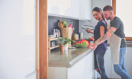 Couple cooking together in their kitchen at homeの写真素材