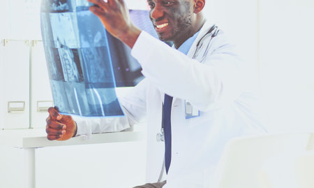 Portrait young african medical doctor holding patients x-rayの写真素材