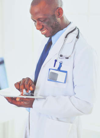 Male black doctor worker with tablet computer standing in hospitalの写真素材