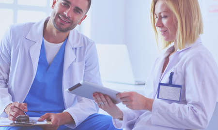Handsome doctor is talking with young female doctor and making nの写真素材