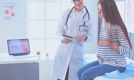 Beautiful smiling pregnant woman with the doctor at hospitalの写真素材