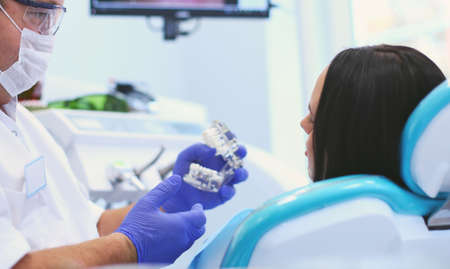 Beautiful senior woman at dentist having dental treatment at dentists officeの写真素材