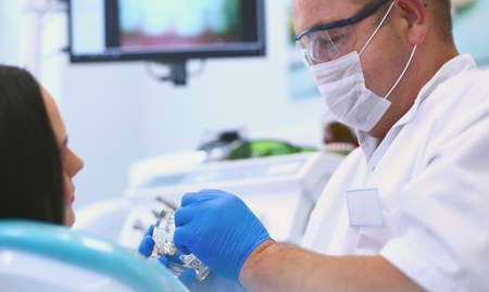 Dentist and his assistant carrying out a thorough examinationの写真素材
