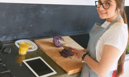 Young woman using a tablet computer to cook in her kitchenの写真素材