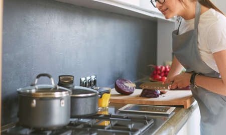 Young woman using a tablet computer to cook in her kitchenの写真素材