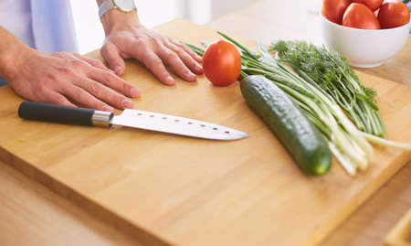 Man preparing delicious and healthy food in the home kitchenの写真素材