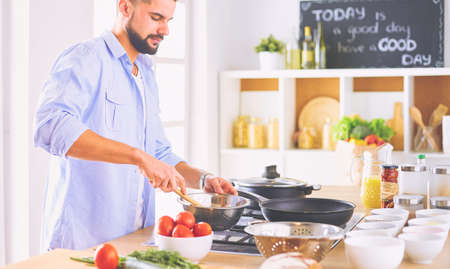 Man preparing delicious and healthy food in the home kitchenの写真素材