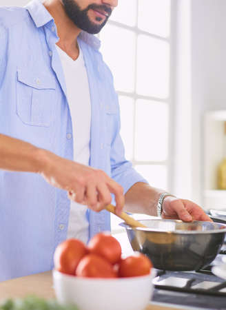 Man preparing delicious and healthy food in the home kitchenの写真素材