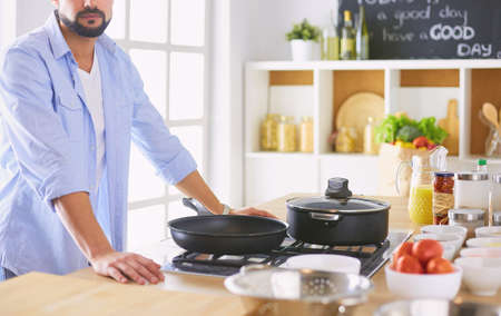 Man preparing delicious and healthy food in the home kitchenの写真素材