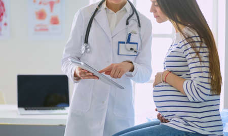 Beautiful smiling pregnant woman with the doctor at hospitalの写真素材