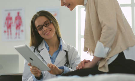 Doctor and patient discussing something while sitting at the table . Medicine and health care conceptの写真素材