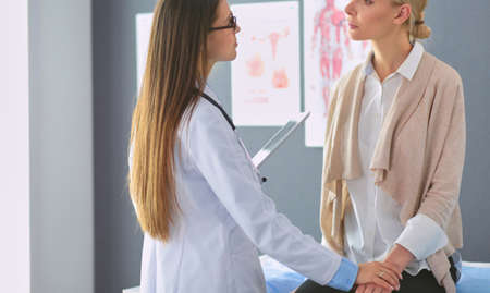 Doctor and patient discussing something while sitting at the table . Medicine and health care conceptの写真素材