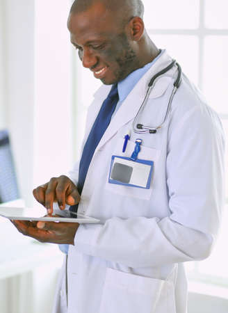 Male black doctor worker with tablet computer standing in hospitalの写真素材