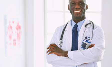 Happy afro man doctor portrait with arms crossedの写真素材