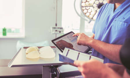 Doctor showing young patient her chest in his office at the hospitalの写真素材