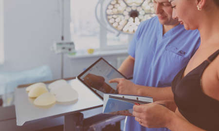Doctor showing young patient her chest in his office at the hospitalの写真素材