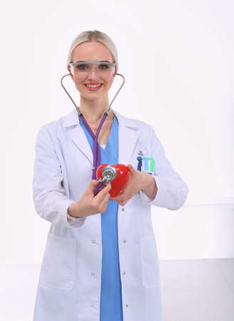 Young woman doctor holding a red heart, isolated on white background. Woman doctorの写真素材