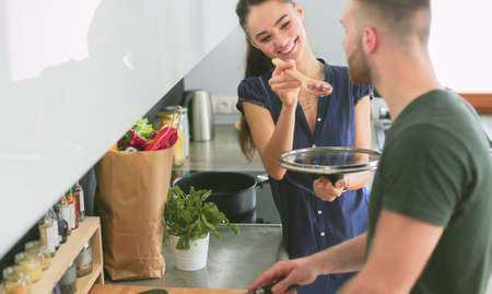 Couple cooking together in their kitchen at homeの写真素材