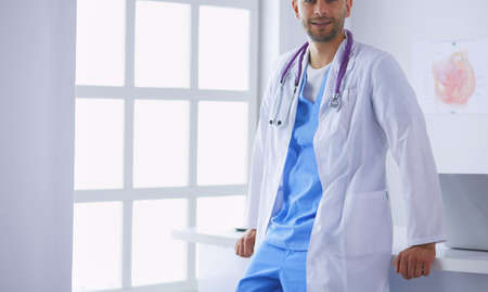 Young and confident male doctor portrait standing in medical office.の写真素材