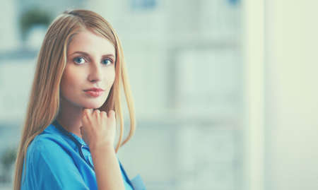 Doctor woman is standing in the near windowの写真素材