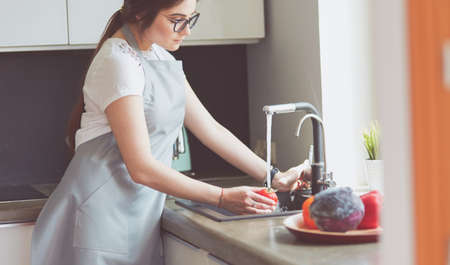 Hands of woman washing vegetables at her kitchenの写真素材