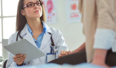 Doctor and patient discussing something while sitting at the table . Medicine and health care conceptの写真素材