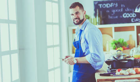 Man holding paper bag full of groceries on the kitchen background. Shopping and healthy food conceptの写真素材