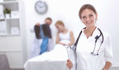 Woman doctor standing with folder at hospitalの写真素材
