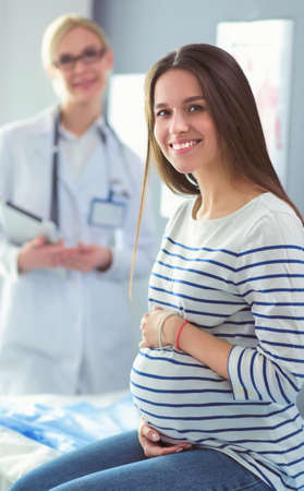 Beautiful smiling pregnant woman with the doctor at hospitalの写真素材