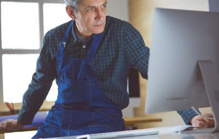 Architect working on drawing table in officeの写真素材