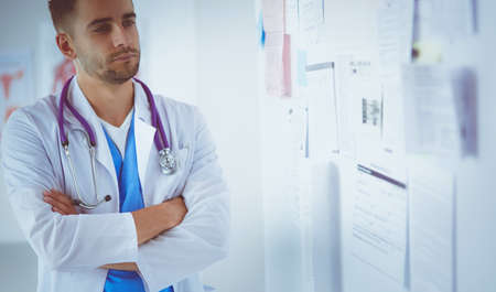 Young and confident male doctor portrait standing in medical officeの写真素材
