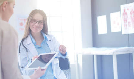 Doctor and patient discussing something while sitting at the table . Medicine and health care conceptの写真素材