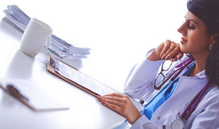 Female doctor sitting on the desk with paper and workingの写真素材