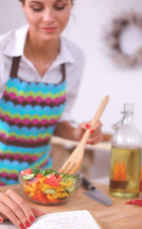 Smiling young woman mixing fresh saladの写真素材