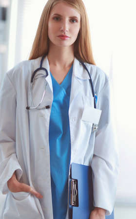 Portrait of woman doctor with folder at hospital corridorの写真素材