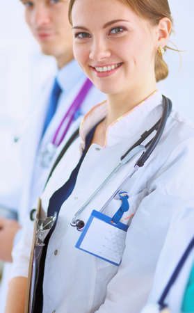 Attractive female doctor with folder in front of medical groupの写真素材