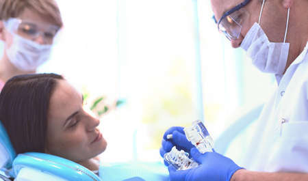 Beautiful senior woman at dentist having dental treatment at dentists officeの写真素材