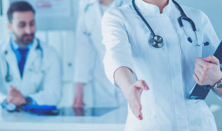Portrait of young beautiful woman doctor giving handshakeの写真素材
